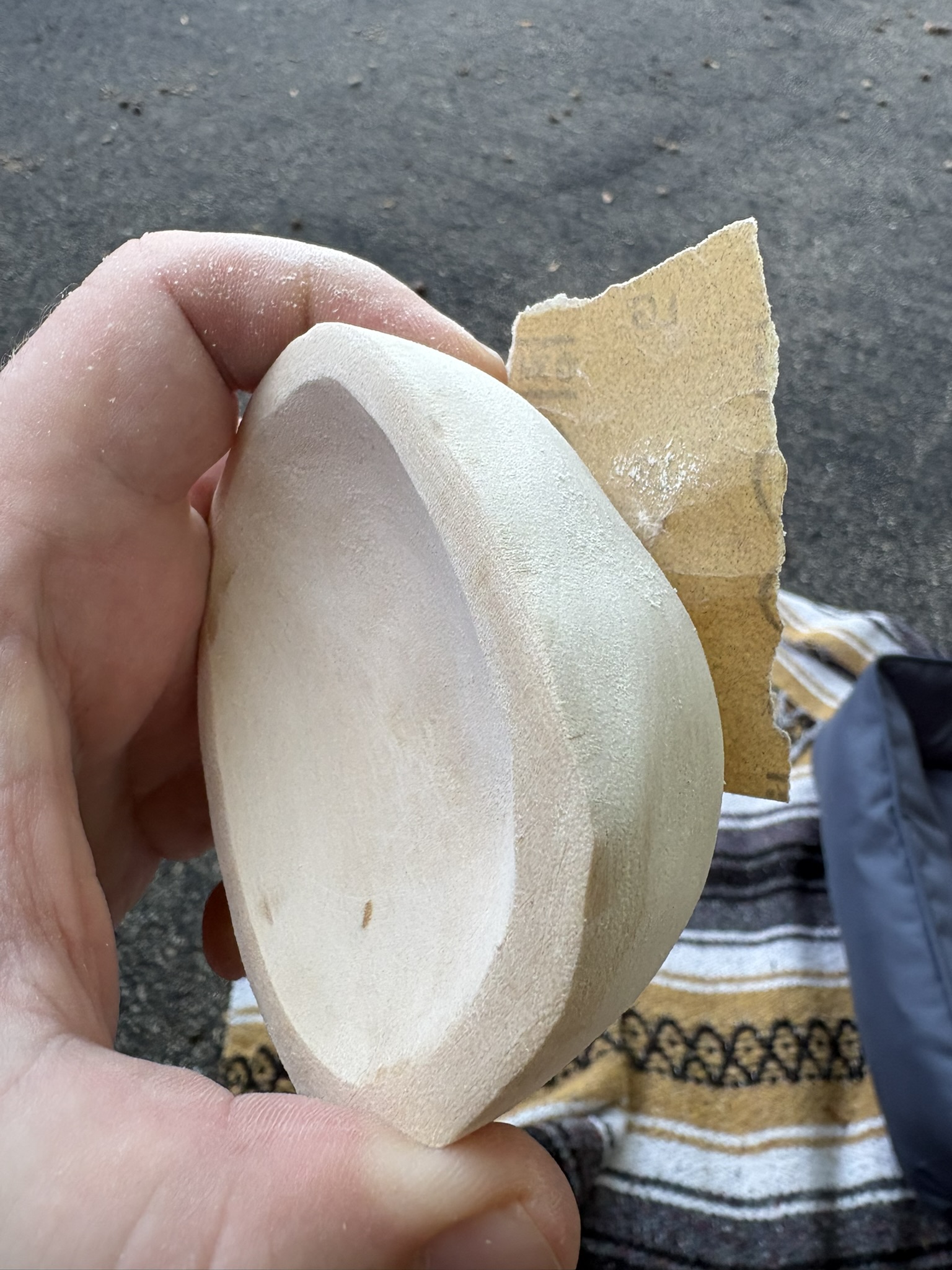 The practice bowl alongside sandpaper during finishing.